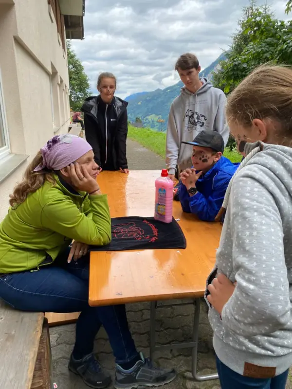 Eine Gruppe von Menschen, die um einen Tisch sitzen. – Jugend und Hund Lager 2020 in Segnas