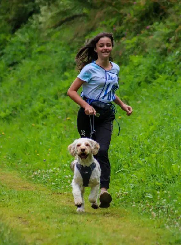 Ein Mädchen läuft mit einem Hund in einem Feld. – Jugend und Hund Lager 2020 in Segnas