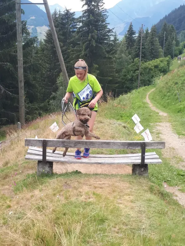 Eine Frau sitzt auf einer Bank mit einem Hund. – Jugend und Hund Lager 2020 in Segnas