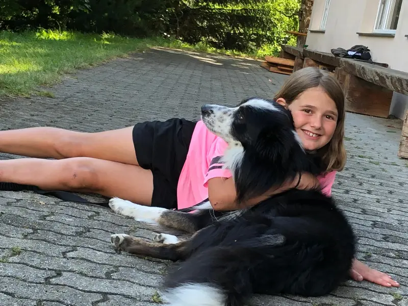 Eine Frau, die mit einem Hund auf dem Boden liegt. – Jugend und Hund Lager 2020 in Segnas