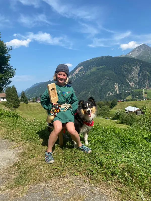Eine Frau, die auf einem Hügel mit einem Hund sitzt. – Jugend und Hund Lager 2021 in Segnas