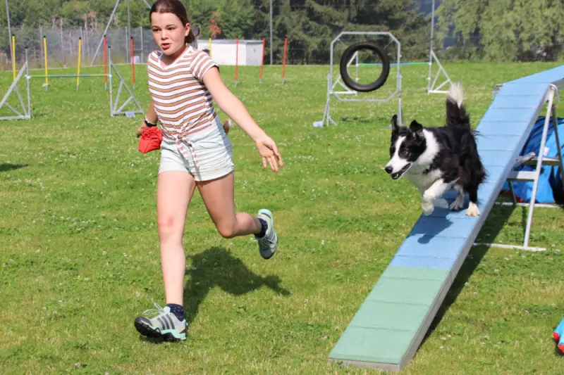 Eine Frau läuft mit einem Hund in einem Park. – Jugend und Hund Lager 2021 in Segnas