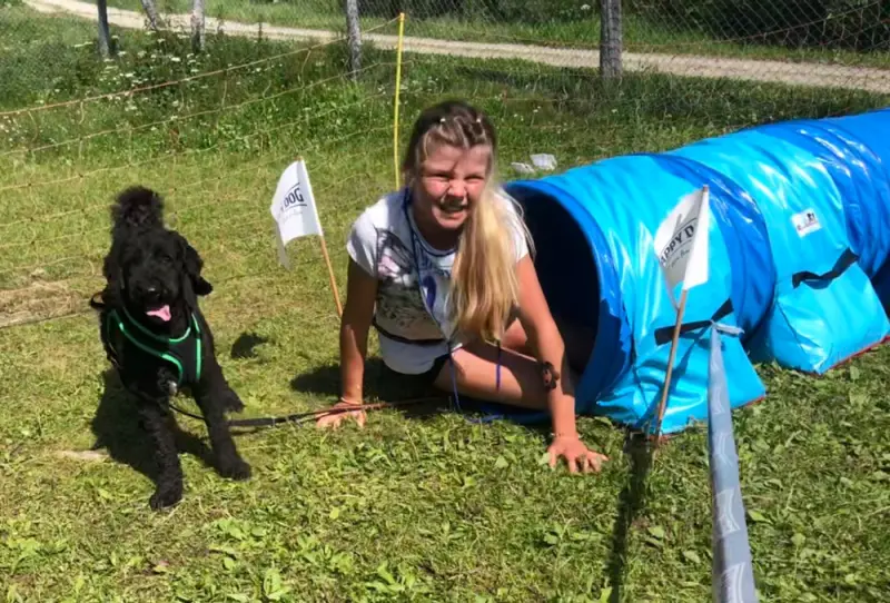 Eine Frau streichelt einen Hund in einer blauen Jacke. – Jugend und Hund Lager 2021 in Segnas