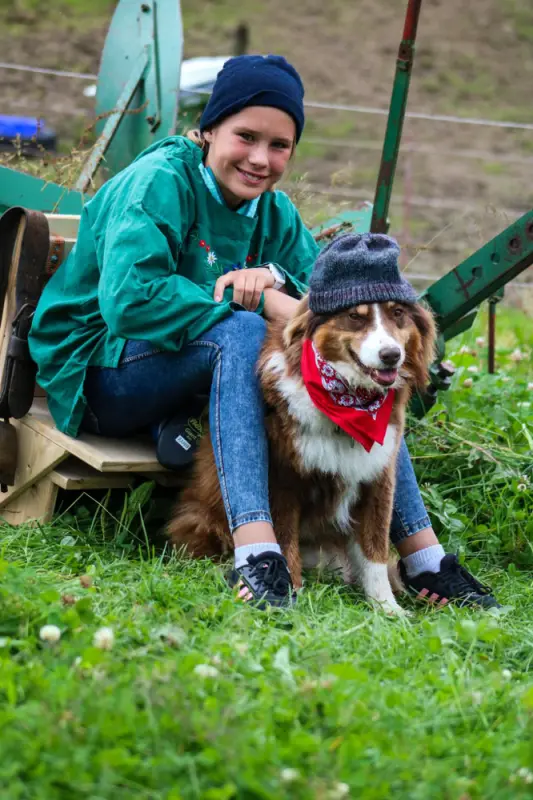 Ein Junge sitzt auf einer Bank mit einem Hund. – Jugend und Hund Lager 2021 in Segnas