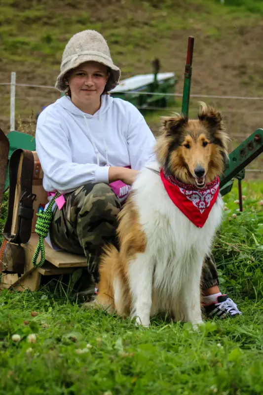 Ein Junge sitzt auf einer Bank mit einem Hund. – Jugend und Hund Lager 2021 in Segnas