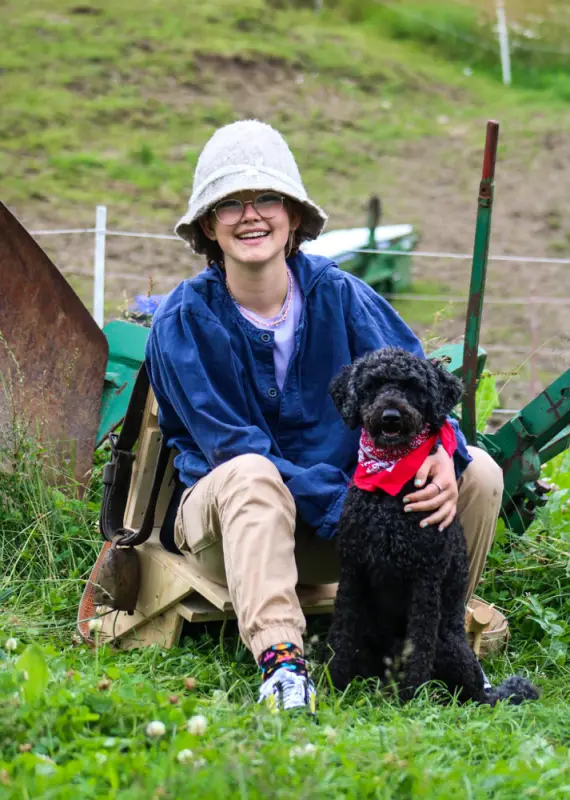 Ein Junge sitzt im Gras mit einem Hund. – Jugend und Hund Lager 2021 in Segnas