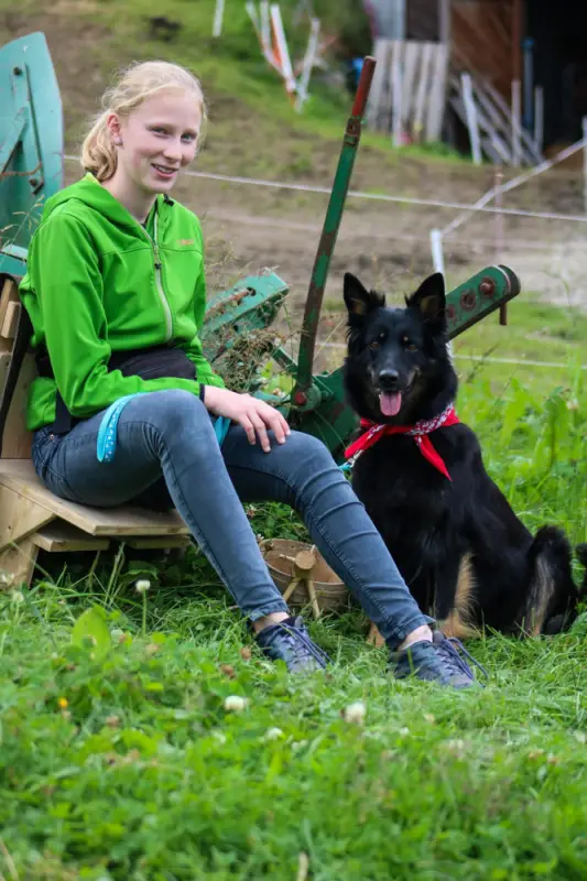 Ein Mädchen sitzt auf einem Stuhl mit einem Hund. – Jugend und Hund Lager 2021 in Segnas
