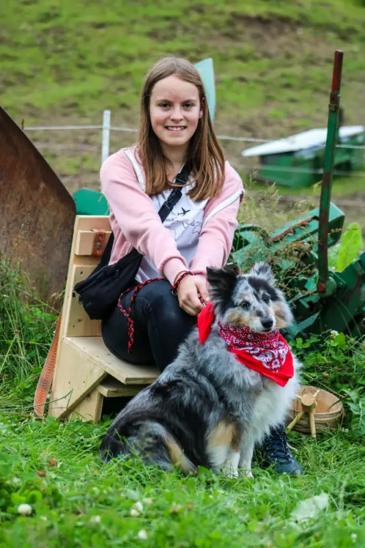 Ein Mädchen sitzt auf einer Bank mit einem Hund. – Jugend und Hund Lager 2021 in Segnas