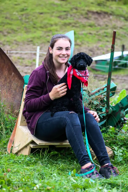 Eine Frau, die auf einer Bank mit einem Hund sitzt. – Jugend und Hund Lager 2021 in Segnas