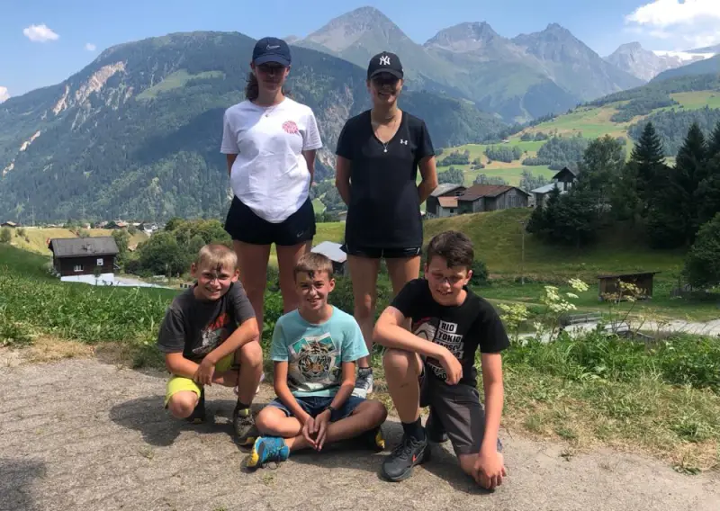 Eine Familie posiert für ein Foto in den Bergen. – Jugend und Hund Lager 2022 in Segnas