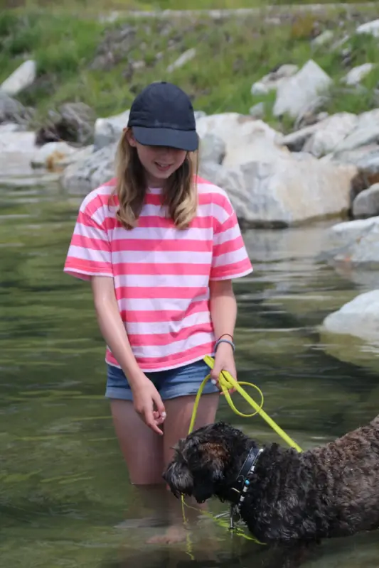 Eine Frau in einem Fluss mit einem Hund. – Jugend und Hund Lager 2022 in Segnas