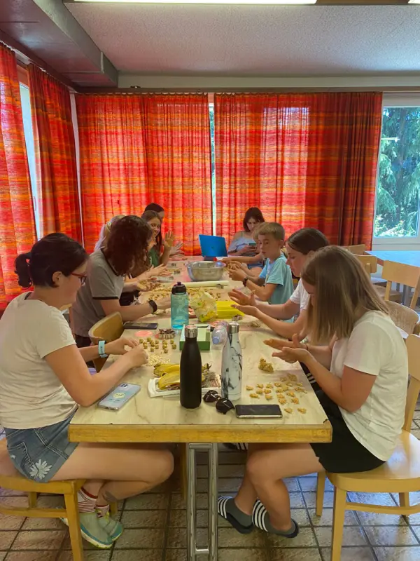 Eine Gruppe von Menschen, die an einem Tisch sitzen und essen. – Jugend und Hund Lager 2022 in Segnas
