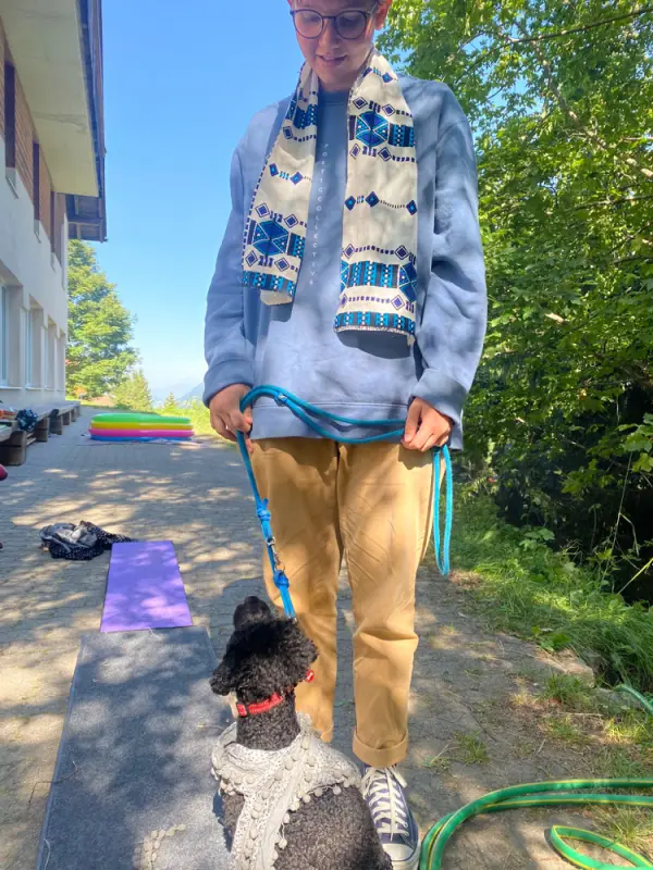 Ein Junge in einem blauen Hemd und braunen Hosen geht einen Hund an der Leine. – Jugend und Hund Lager 2022 in Segnas