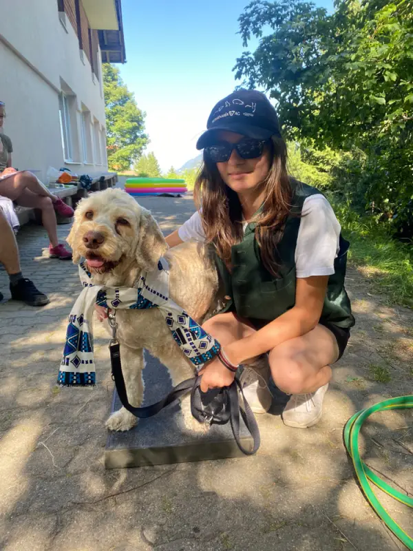 Eine Frau, die mit einem Hund an der Leine kniet. – Jugend und Hund Lager 2022 in Segnas