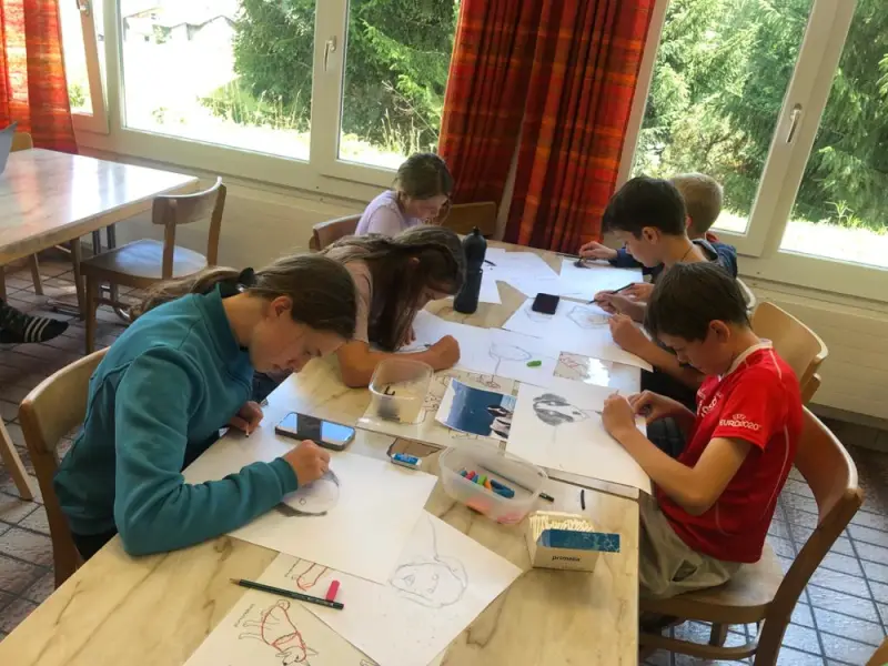 Studenten, die an ihren Zeichnungen im Klassenzimmer arbeiten. – Jugend und Hund Lager 2023 in Segnas