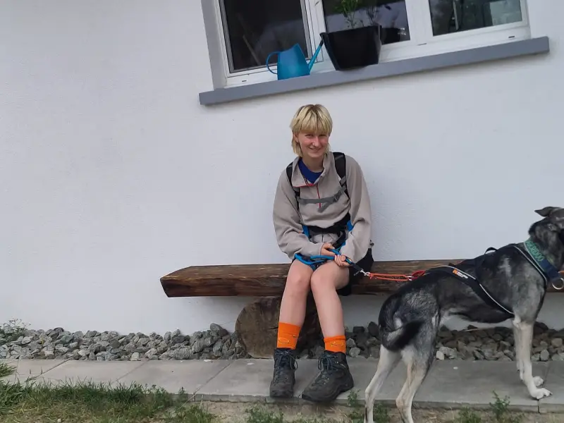 Eine Frau, die auf einer Bank mit einem Hund sitzt. – Jugend und Hund Lager 2024 in Segnas