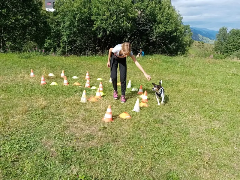 Eine Frau spielt mit Kegeln im Gras. – Jugend und Hund Lager 2024 in Segnas
