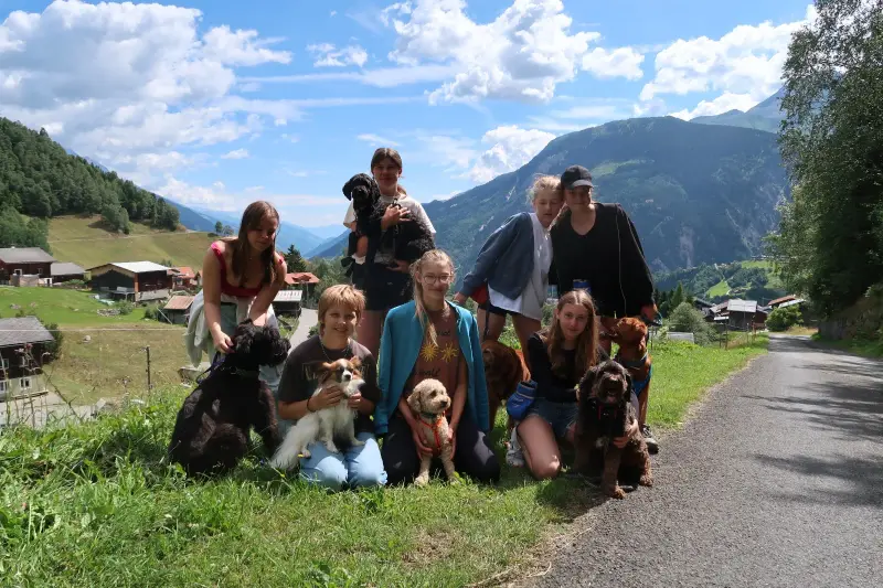Eine Gruppe von Menschen und ihren Hunden posiert für ein Bild. – Jugend und Hund Lager 2024 in Segnas