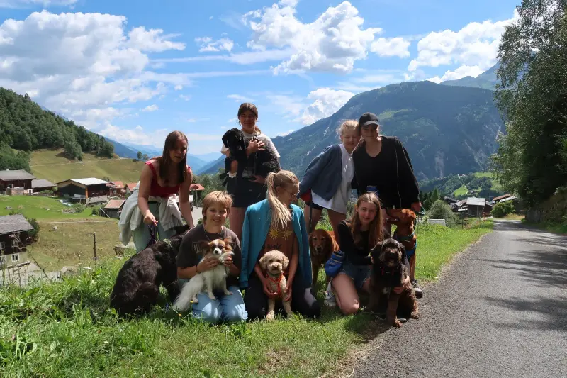 Eine Gruppe von Menschen und ihren Hunden posiert für ein Bild. – Jugend und Hund Lager 2024 in Segnas