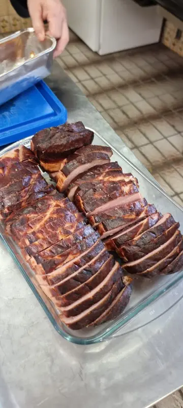 Eine Person legt ein Stück Fleisch in eine Glasschüssel. – Jugend und Hund Lager 2024 in Segnas