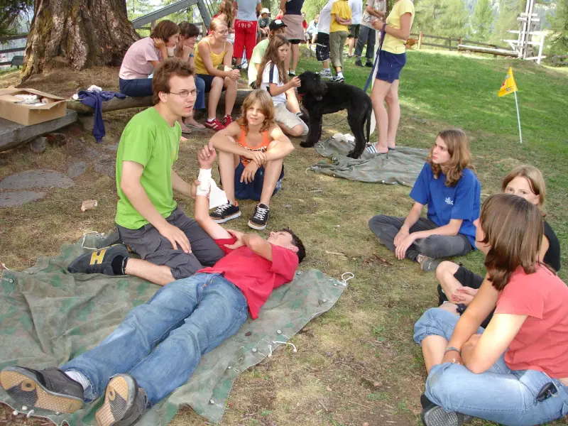 Eine Gruppe von Menschen, die auf dem Boden sitzen. – Jugend und Hund Lager 2006 in Trans