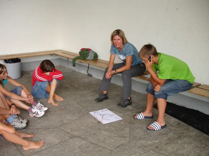 Eine Gruppe von Menschen, die auf dem Boden sitzen. – Jugend und Hund Lager 2006 in Trans