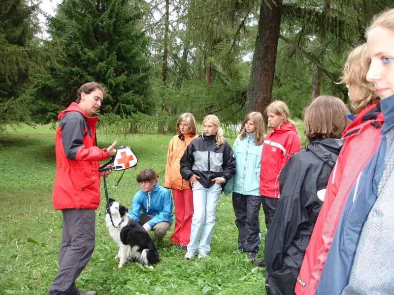 Eine Gruppe von Menschen, die um einen Hund stehen. – Jugend und Hund Lager 2006 in Trans