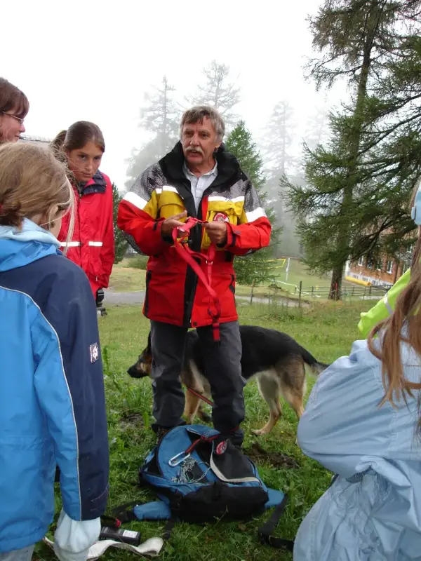 Eine Gruppe von Menschen, die um einen Hund stehen. – Jugend und Hund Lager 2006 in Trans