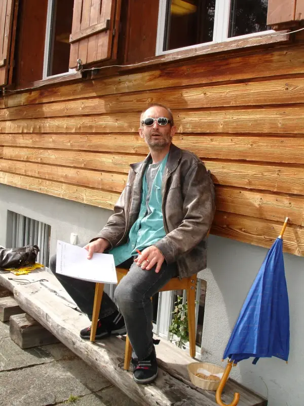 Ein Mann sitzt auf einer Bank mit einem Laptop. – Jugend und Hund Lager 2006 in Trans