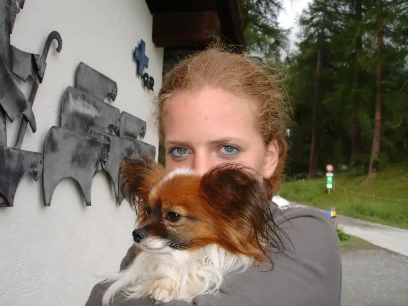 Eine Frau, die einen kleinen Hund in ihren Armen hält. – Jugend und Hund Lager 2006 in Trans