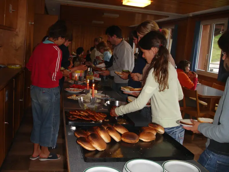 Eine Gruppe von Menschen, die um einen Tresen stehen. – Jugend und Hund Lager 2006 in Trans