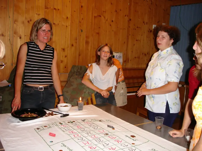 Eine Gruppe von Menschen, die um einen Tisch stehen. – Jugend und Hund Lager 2006 in Trans