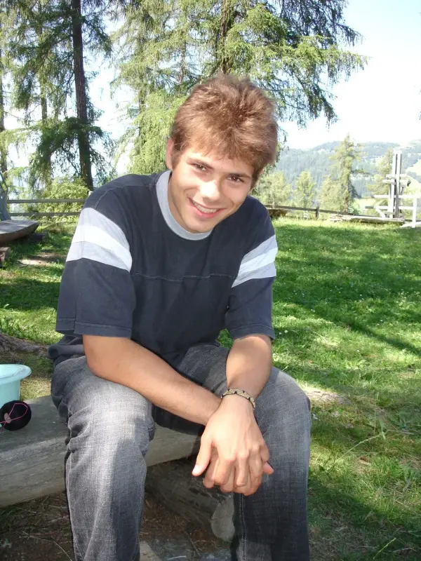 Ein junger Mann sitzt auf einer Bank in einem Park. – Jugend und Hund Lager 2007 in Trans