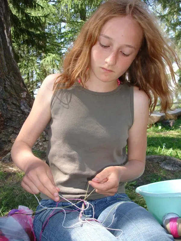 Ein Mädchen, das mit einer Schnur auf dem Boden sitzt. – Jugend und Hund Lager 2007 in Trans