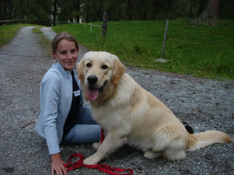 Eine Frau, die neben einem Hund kniet. – Jugend und Hund Lager 2007 in Trans