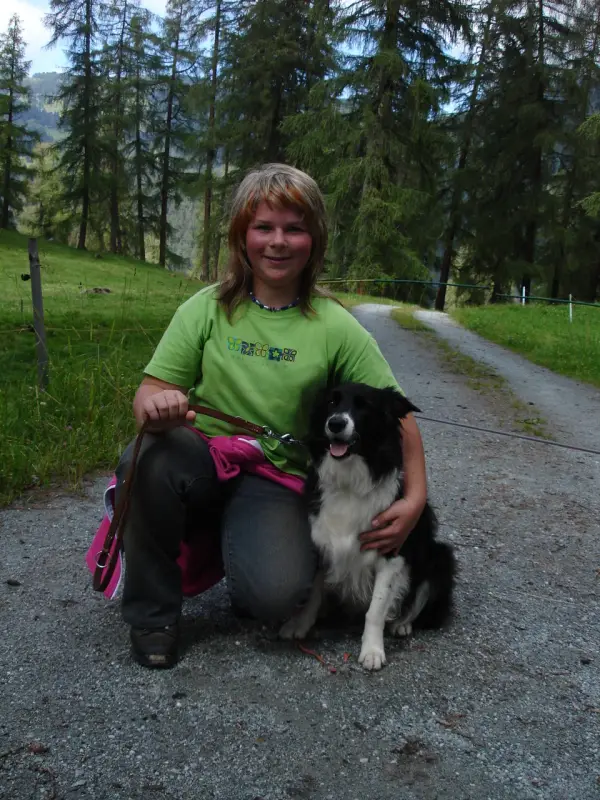 Ein Mädchen, das mit einem Hund auf dem Boden sitzt. – Jugend und Hund Lager 2007 in Trans