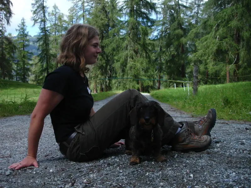 Eine Frau, die mit einem Hund auf dem Boden sitzt. – Jugend und Hund Lager 2007 in Trans