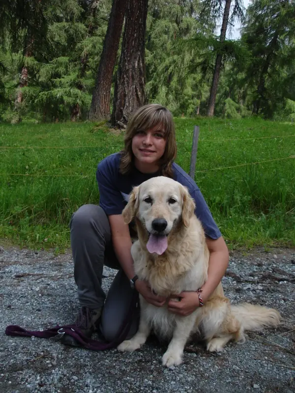 Eine Frau kniet mit einem Hund in ihrem Schoss nieder. – Jugend und Hund Lager 2007 in Trans