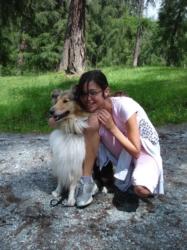 Eine Frau kniet mit einem Hund in ihrem Schoss nieder. – Jugend und Hund Lager 2007 in Trans