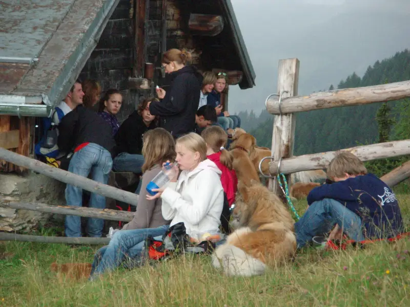 Eine Gruppe von Menschen, die auf einem Hügel sitzen. – Jugend und Hund Lager 2007 in Trans