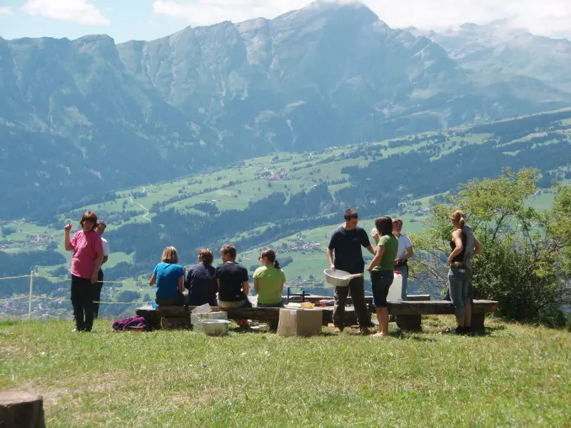 Eine Gruppe von Menschen, die auf einem Hügel sitzen. – Jugend und Hund Lager 2007 in Trans