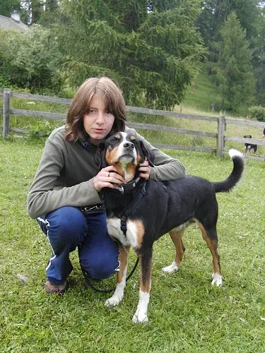 Eine Frau, die mit einem Hund niederkniet. – Jugend und Hund Lager 2008 in Trans