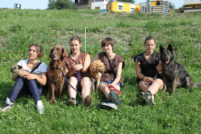 Eine Gruppe von Mädchen, die im Gras sitzen. – Jugend und Hund Lager 2012 in Vignogn