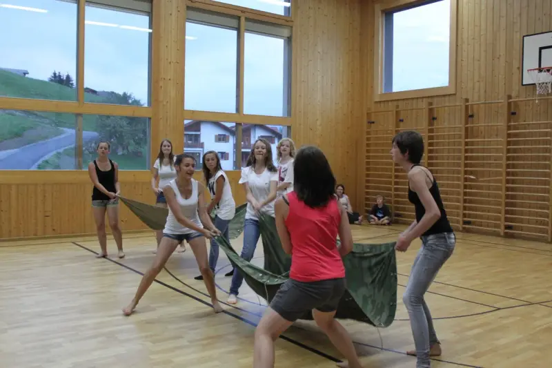 Eine Gruppe von Frauen, die in einer Turnhalle ein Netzballspiel spielen. – Jugend und Hund Lager 2012 in Vignogn